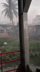 Rainy day ferry operations and waterfront activity in Dhaka