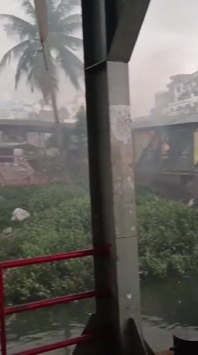 Rainy day ferry operations and waterfront activity in Dhaka