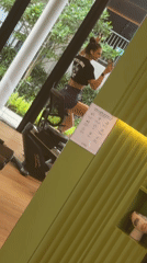 Woman multitasks with phone during gym workout in Thailand