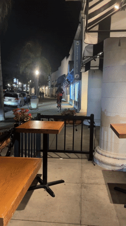 Person on power stilts carries American flag through Coronado