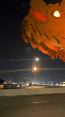 Night traffic crosses illuminated dragon bridge in Đà Nẵng