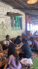 Chess players at a rustic mountain cafe in Haini