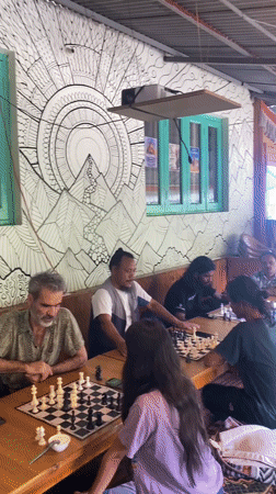 Chess players at a rustic mountain cafe in Haini
