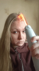 Woman uses electrical therapy device with cat in snowy Samara