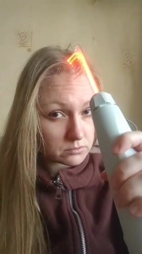 Woman uses electrical therapy device with cat in snowy Samara