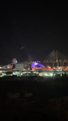 Night festival in Loures with Ferris wheel and bridge backdrop