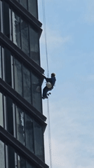 Window cleaner rappels down Moscow skyscraper during morning work