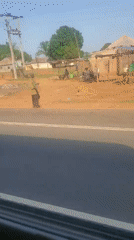 Vehicle passenger films roadside scenery in Gwagwada, Nigeria