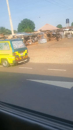 Vehicle passenger films roadside scenery in Gwagwada, Nigeria