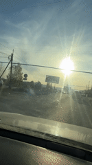 Vehicle approaches railroad crossing in bright sunlight near Turgoyak