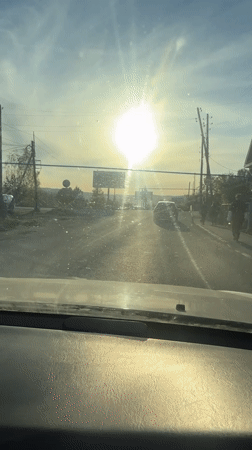 Vehicle approaches railroad crossing in bright sunlight near Turgoyak
