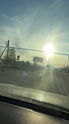 Vehicle approaches railroad crossing in bright sunlight near Turgoyak