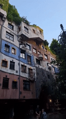 Tourist documents Vienna's colorful Hundertwasserhaus building from multiple angles