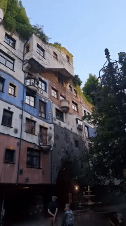 Tourist documents Vienna's colorful Hundertwasserhaus building from multiple angles