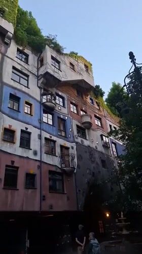 Tourist documents Vienna's colorful Hundertwasserhaus building from multiple angles