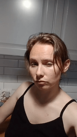 Woman makes facial expressions in Yekaterinburg kitchen setting