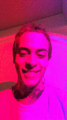 Tattooed artist paints in Buenos Aires studio amid colored lights