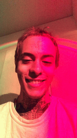 Tattooed artist paints in Buenos Aires studio amid colored lights