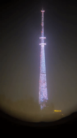 Public telescope captures colorful tower lights through fog in Irkutsk