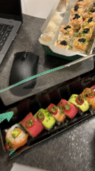 Takeout sushi meal documented beside laptop in Saint Petersburg
