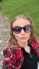 Woman in plaid jacket walks through urban park