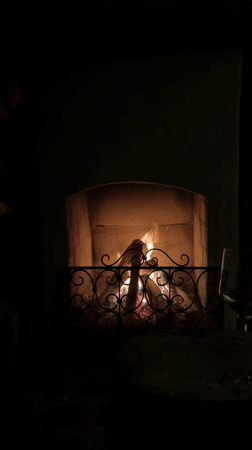 Person tends fireplace in San Lorenzo di Sebato