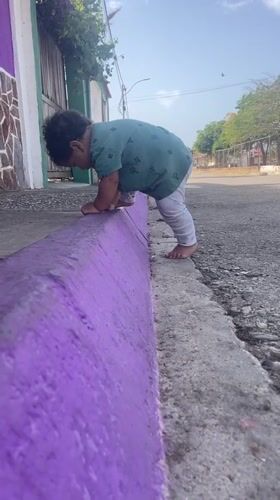 Toddler plays outdoors in Altagracia amid domestic Venezuelan scenes