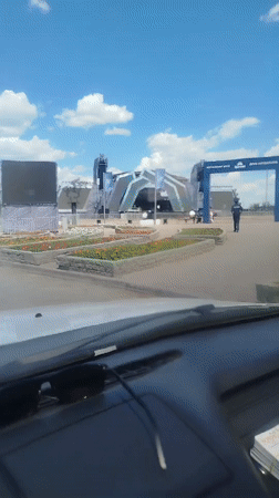 View from a parked car facing something large outside