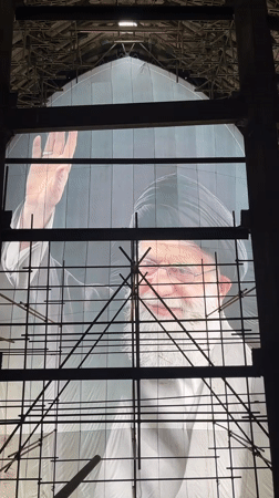 Large portrait with raised hand on display in Tehran