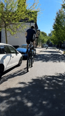 Cyclist rides custom tall bicycle through London street