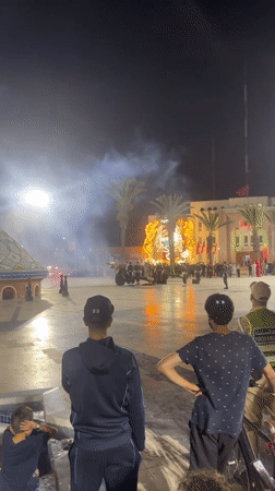 Cannon fire and lights at a nighttime plaza event in Safi