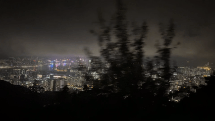 Hong Kong cityscape observed from height under cloudy night sky