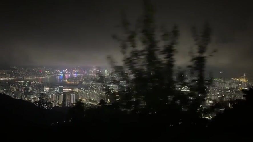 Hong Kong cityscape observed from height under cloudy night sky