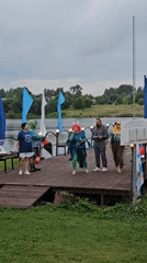 Costumed characters and a mic on a waterside pier in Elovo