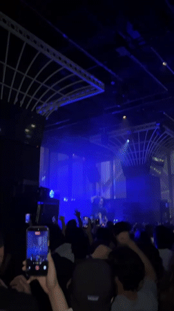 Concert performer takes stage under blue lights in Hong Kong
