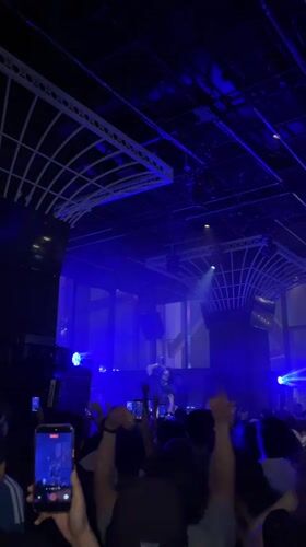 Concert performer takes stage under blue lights in Hong Kong