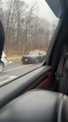 Police car with flashing lights stops Mercedes on roadside