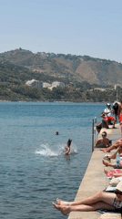Sunny pier day in Cefalù — sunbathing and jumping into the sea