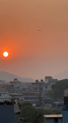 Sunset observed over Pokhara cityscape with airplane visible