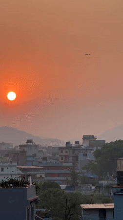 Sunset observed over Pokhara cityscape with airplane visible