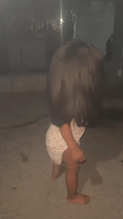 Toddler plays outdoors at night in Ado, Nigeria