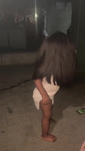 Toddler plays outdoors at night in Ado, Nigeria
