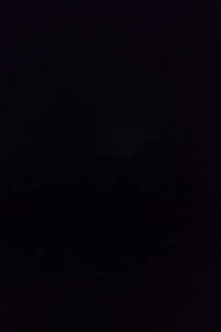 The video begins with a black screen. After a moment, a faint rectangular shape appears in the center of the screen, illuminated by an unseen light source. The shape appears to be a projected image or a light source in a dark environment. The rest of the scene remains predominantly dark and indistinct, with no discernible objects or figures clearly visible. The faint rectangle flickers slightly but otherwise remains static. The duration of the video is approximately 4 seconds.