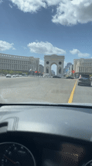 Driver approaches Triumphal Arch in Astana under clear skies