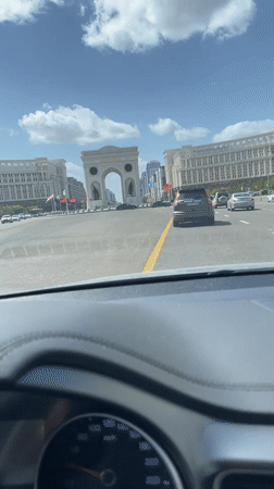 Driver approaches Triumphal Arch in Astana under clear skies