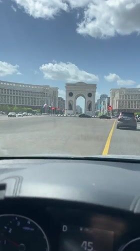 Driver approaches Triumphal Arch in Astana under clear skies