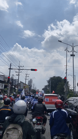 Motorcyclists wait at traffic light in Banjarkemantren, Indonesia