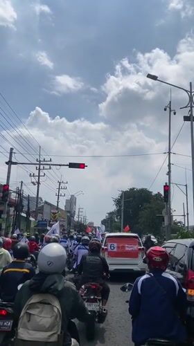 Motorcyclists wait at traffic light in Banjarkemantren, Indonesia