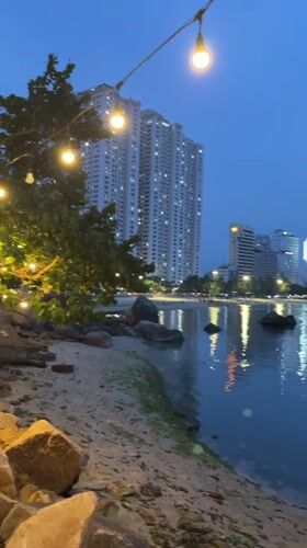 Couple takes selfies at Nha Trang waterfront amid city skyline