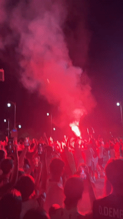 Night street celebration in Dénia with flares and Spanish flags